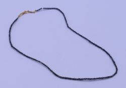 An 18 K gold and black diamond necklace, the clasp marked UNOAERRE. 40 cm long. 2.