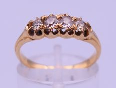 An unmarked high carat gold five-stone diamond ring. Ring size N. 3 grammes total weight.