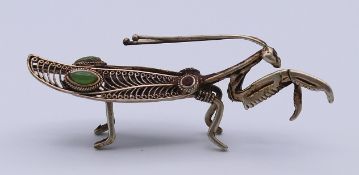 A filigree praying mantis. 9 cm long.