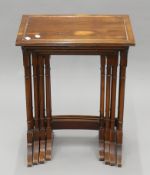 A 20th century nest of four yew wood tables. 50 cm wide.