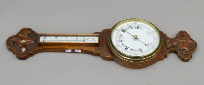 A Victorian oak aneroid barometer. 81 cm long.