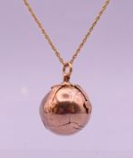 A 9 ct gold cased Masonic ball folding cross pendant on a 9 ct gold chain. The ball 2.25 cm high.