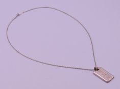 A Tiffany & Co silver Atlas dog tag on a silver chain. Tag 3 cm high including suspension loop.