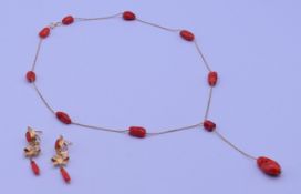 An 18 ct gold and coral necklace and earrings. The necklace 44 cm long. 12 grammes total weight.