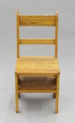 An oak metamorphic library chair, made by the wood turner Peter Stock. 38.5 cm wide.
