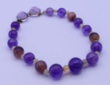 A blue john and amethyst bead necklace, brooch and earrings. The necklace 42 cm long.