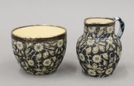 A Macintyre Moorcroft silver-rimmed milk jug and sugar bowl. The former 7 cm high.