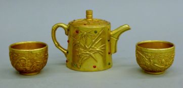 A Chinese bronze teapot and two tea bowls. The former 9.5 cm high.