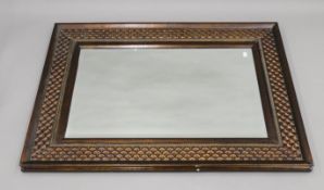 A large decorative bevelled wall mirror. 111 x 80 cm.