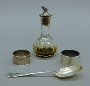 Two silver napkin rings, a silver spoon and a silver-topped glass vinaigrette. The latter 12.