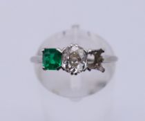 A platinum, emerald and diamond ring (lacking one stone). Ring size N/O.2.8 grammes total weight.
