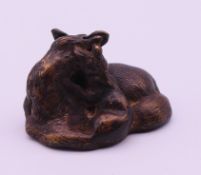 A bronze model of a vixen with cub. 4 cm wide.
