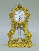A small gilt mantle clock with enamel dial. 19 cm high.