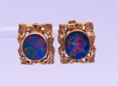 A pair of 9 ct gold opal earrings. Each 1.5 cm high. 4.7 grammes total weight.
