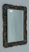 A Chinese carved wooden-framed bevelled wall mirror. 42.5 x 29.5 cm overall.