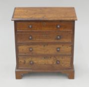 A mahogany miniature chest of drawers. 25 cm high x 23 cm wide.