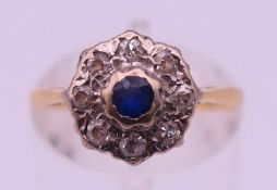 An 18 ct gold diamond and sapphire flower head ring. Ring size N. 2.9 grammes total weight.