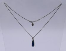 A silver, black opal and diamond pendant necklace. The necklace 42 cm long.