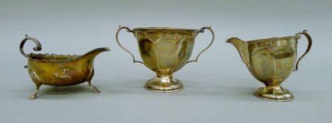 A silver cream jug, a silver sugar bowl and a silver sauce boat,