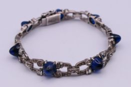 An Art Deco bracelet set with white stones and blue cabochons. 17 cm long.