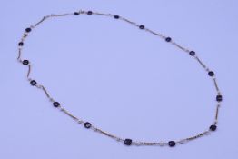 A silver gilt garnet and pearl necklace. 90 cm long.