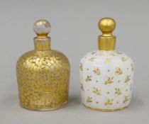 Two Victorian gilt-decorated glass scent bottles. Each 11 cm high.