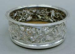 An embossed silver bottle coaster. 15 cm diameter.