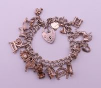 A silver charm bracelet with various charms and a silver padlock fastening. Bracelet 18 cm long. 46.