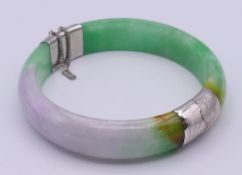 An 18 K white gold plated and jade bangle. 6 cm inner diameter.