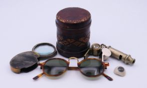 Three whistles, a pair of sunglasses, a leather-covered cigarette tin,