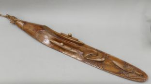 A Papua New Guinean wooden wall hanging carved with stylized face and creatures. 118 cm high.