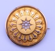 A Victorian unmarked gold seed pearl mounted mourning brooch. 3.5 cm diameter. 10.