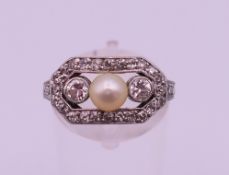 A boxed unmarked yellow and white gold or platinum diamond and pearl ring. Ring size P. 3.