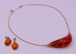A 9 ct gold and amber necklace and earrings. The necklace 42 cm long. 21.1 grammes total weight.
