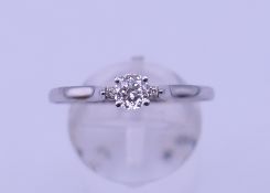 An 18 ct unmarked white gold diamond solitaire ring. The claw set stone 0.