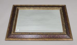 A large decorative bevelled wall mirror. 101 x 75.5 cm.