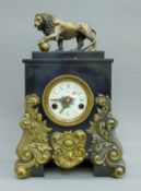 A black slate mantle clock surmounted with a bronze lion. 45 cm high.