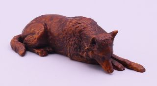 A small carved wooden model of a wolf. 10 cm long.