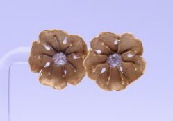 A pair of unmarked gold and diamond floral earrings, with silver backs. Each 1.5 cm diameter. 4.