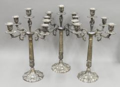 Three modern cast metal candelabra. Each 55 cm high.