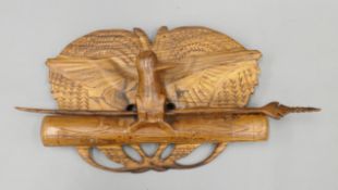 A Papua New Guinean wall hanging carved with a bird. 51 cm wide.