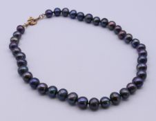 A black pearl necklace. 44 cm long.