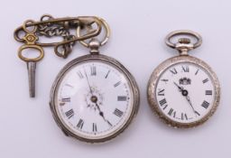 Two silver fob watches, one with key. Largest 4 cm diameter.