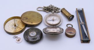 A collection of compasses, including a World War II German example. The latter 2 cm diameter.