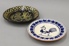 A slipware pottery dish and another, each decorated with chickens. The former 31 cm diameter.