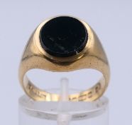 A 9 ct gold and onyx signet ring. Ring size M. 6.1 grammes total weight.