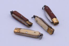 Four miniature penknives, two with bone handles. Each approximately 4.5 cm long open.