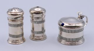 A three-piece silver condiment set. The mustard 4 cm high and 20 grammes.