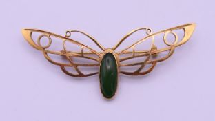 An 18 ct gold brooch formed as a winged insect set with a green cabochon stone, possibly jade. 6.