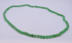 A jade bead necklace. 98 cm long.